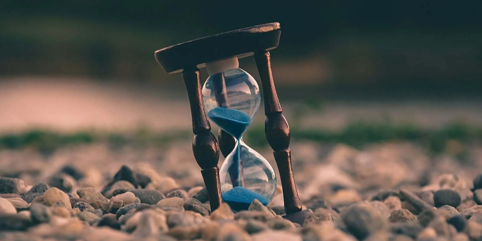 Hourglass on pebbles symbolizing Time, Health and the Things That Really Matter.