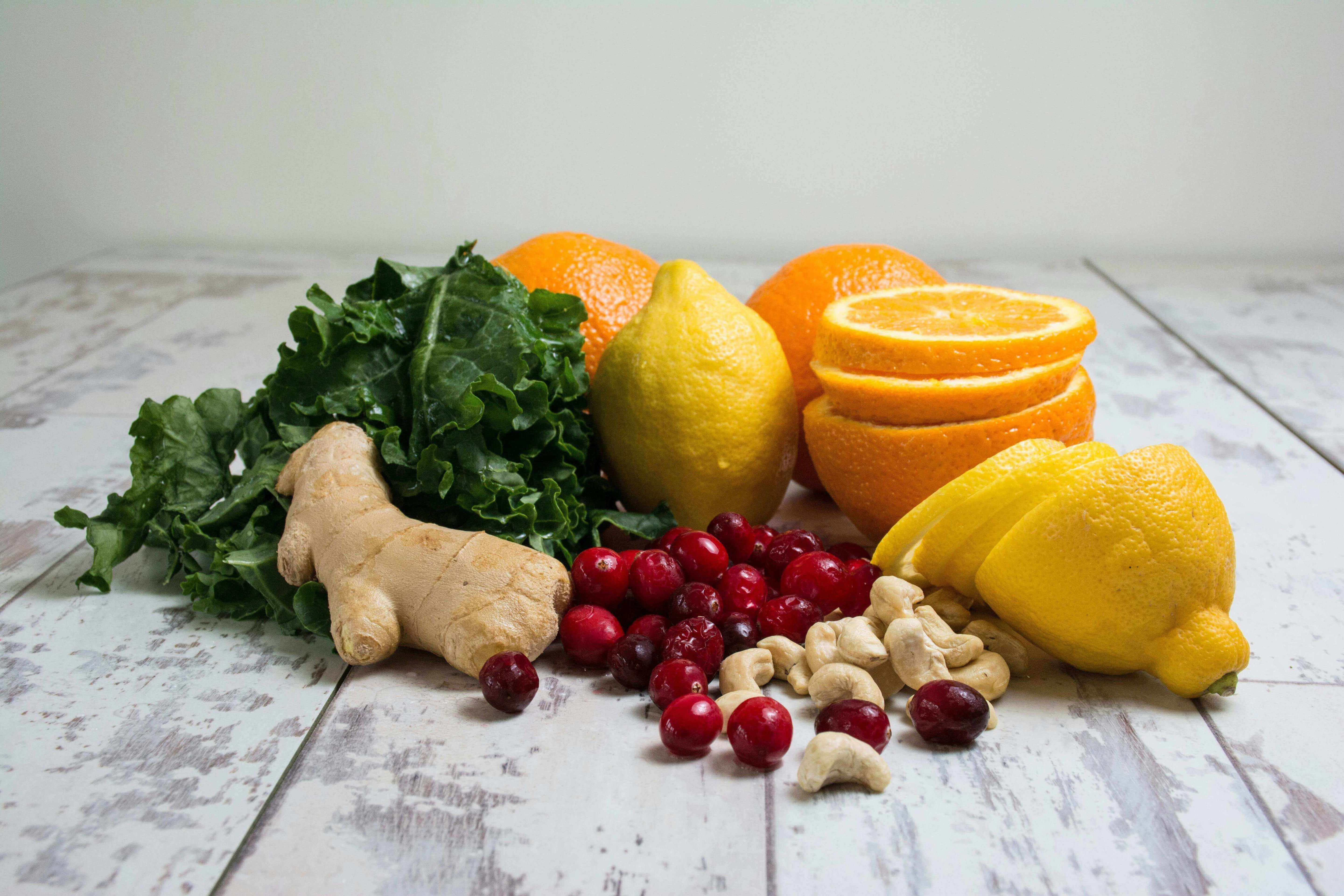 Fresh fruits and vegetables including lemons, oranges, ginger, kale, and cranberries for immune support - Windback NZ