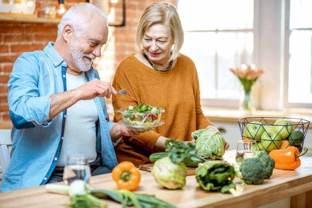 How to Age Gracefully: Lifestyle Choices That Make a Difference with a couple enjoying healthy food preparation.