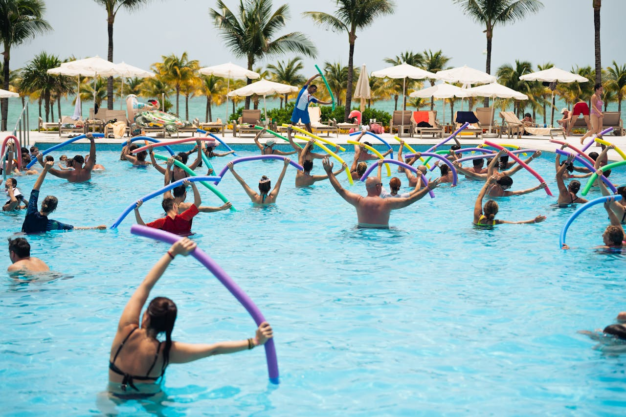 Aqua aerobics class in a pool, demonstrating strong, energised and ageless women exercising together - Windback NZ.