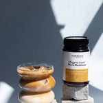 Matakana Superfoods Lion's Mane Mushroom Powder 120g with iced coffee in a glass and decorative stones.
