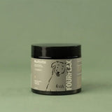 Jar of Fourflax dog multivitamin product on a green background
