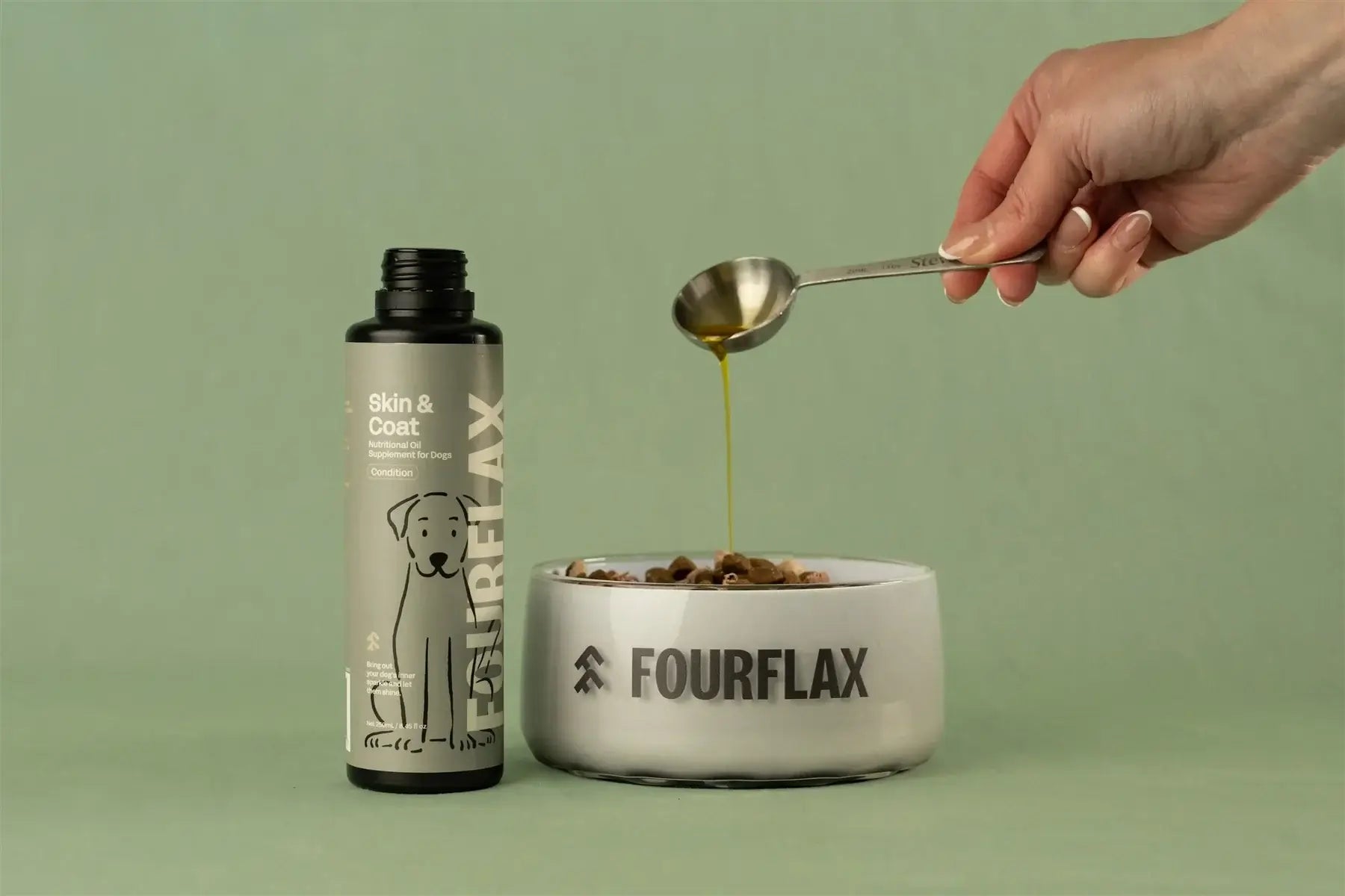 Fourflax pet product being poured into a bowl with a spoon on a green background